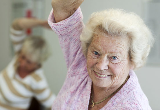 Foto: Eine Seniorin beim Tanz/ bei der Gymnastik.